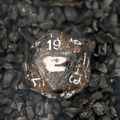 T-Rex bone D20 carved from solid fossil, held in hand