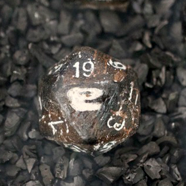 T-Rex bone D20 carved from solid fossil, held in hand