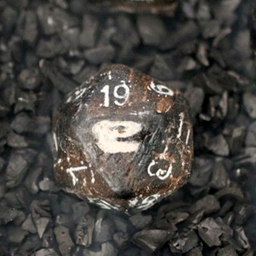 T-Rex bone D20 carved from solid fossil, held in hand